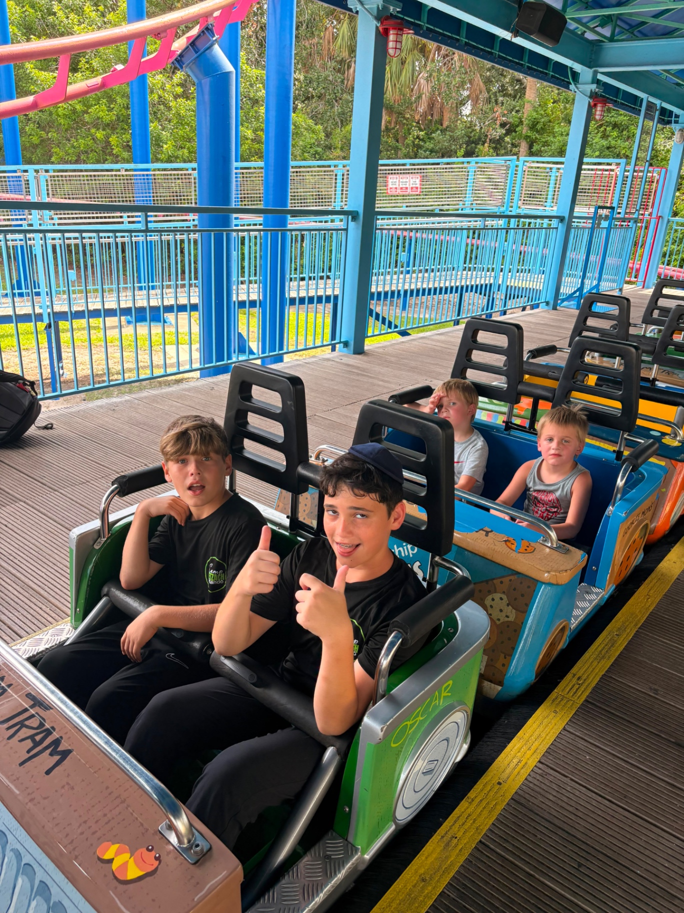 Two campers giving thumbs-up from the front car of a roller coaster