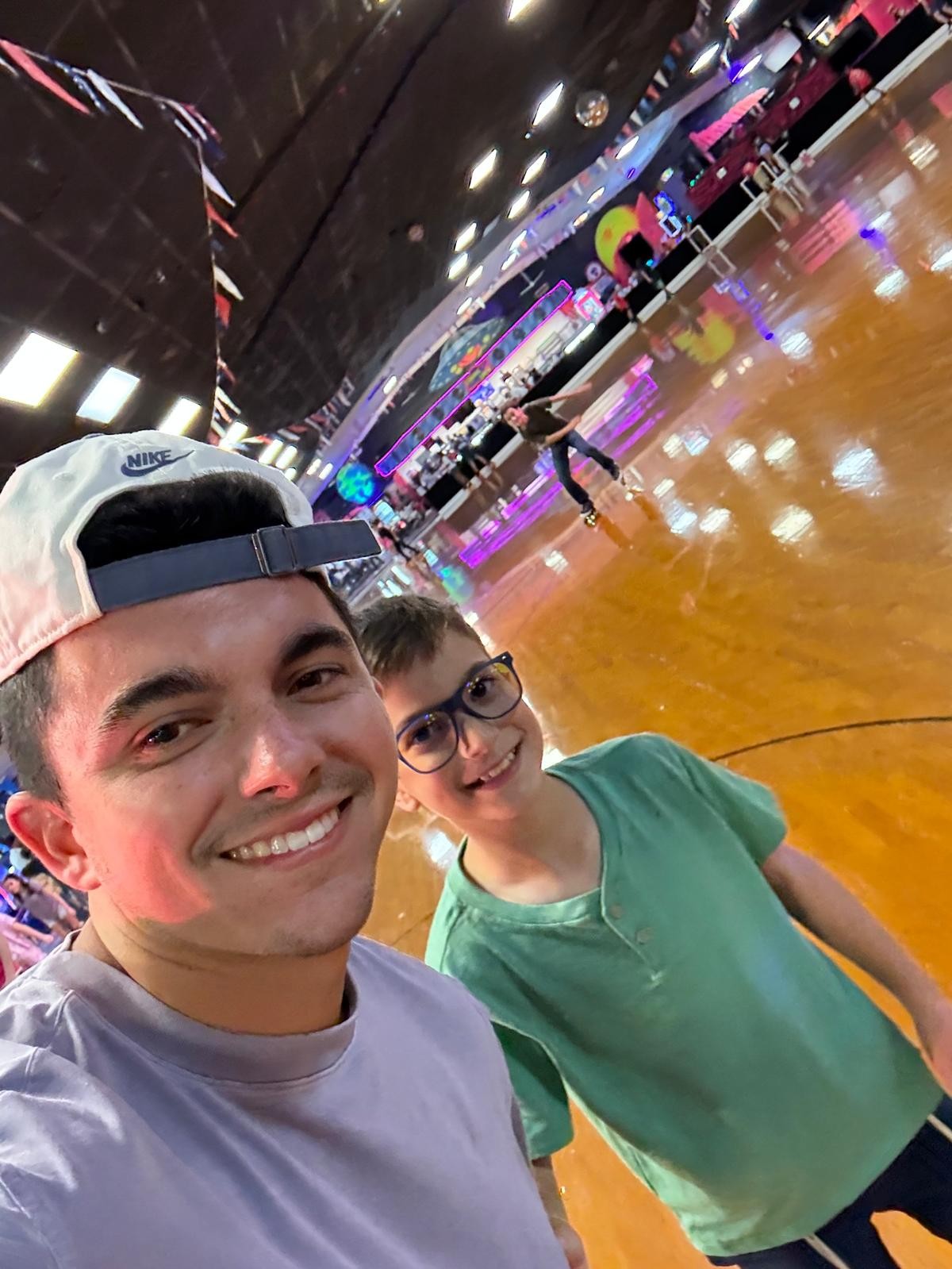 A counselor and a camper taking a selfie at a roller skating rink