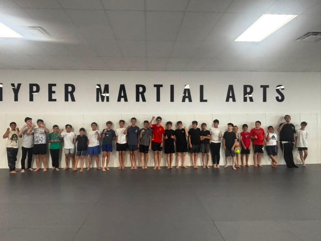 Campers lined up on the mats at a martial arts studio