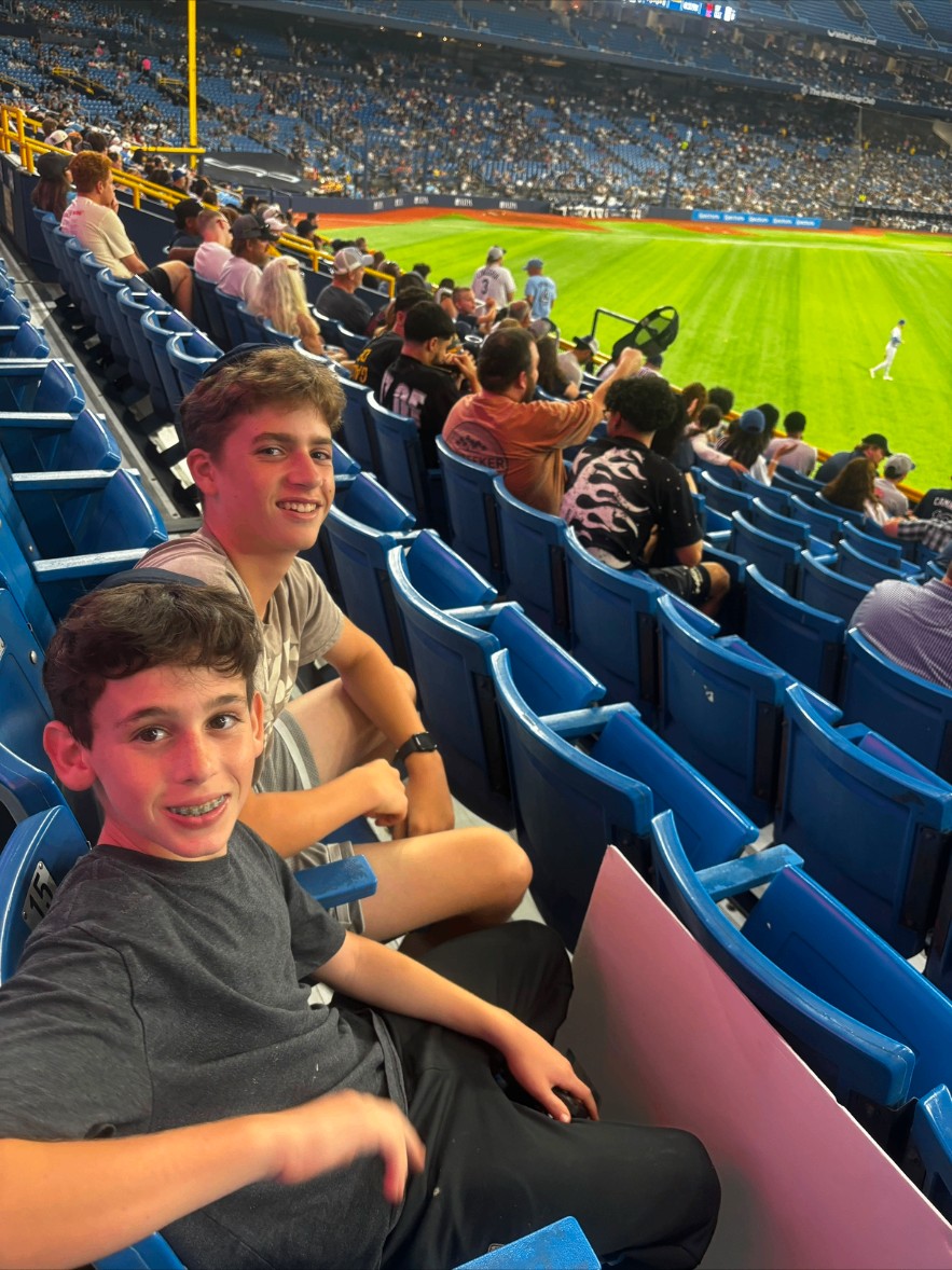Two campers watching a baseball game from stadium seats