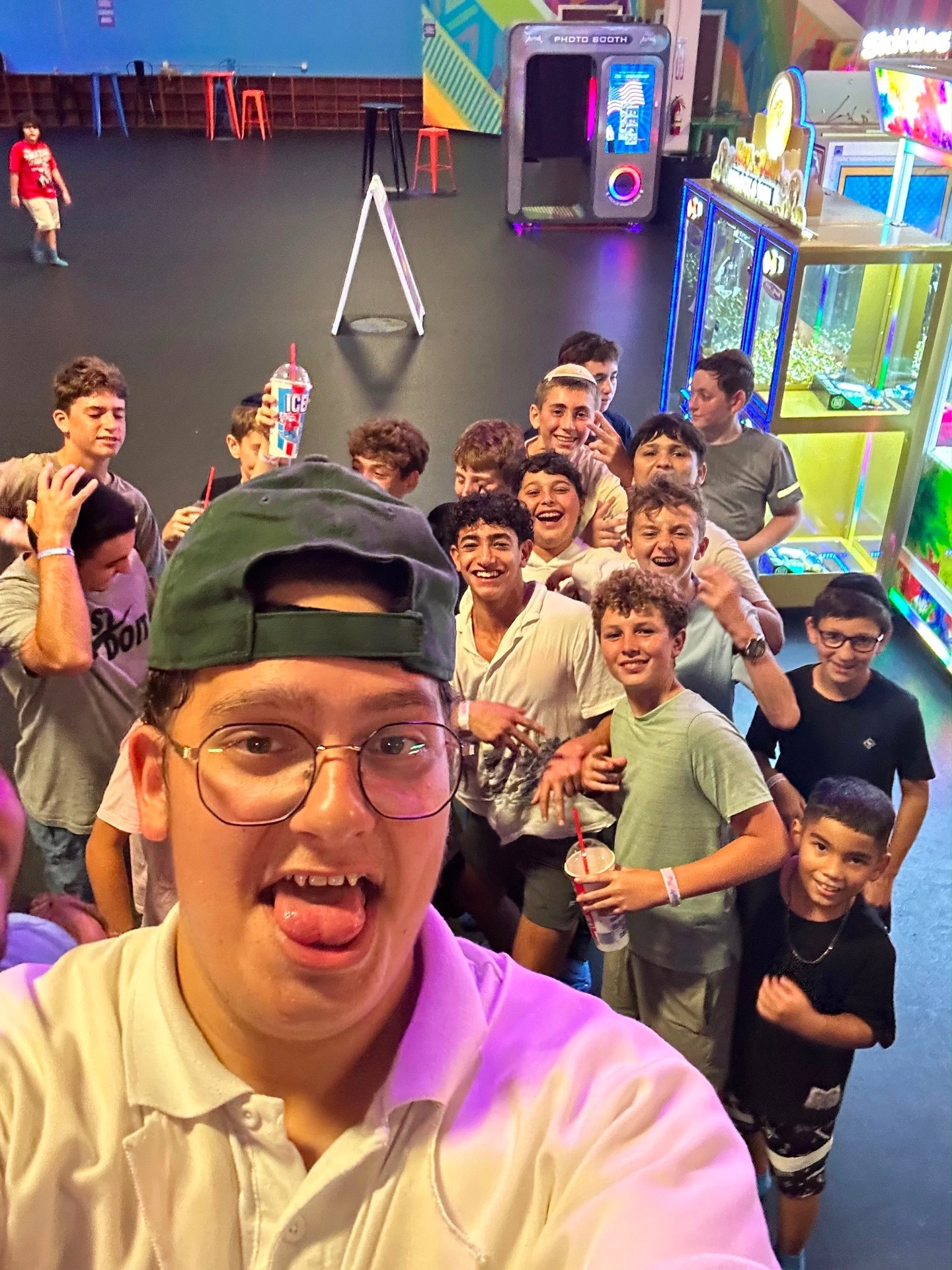 Campers taking a group selfie together at an arcade