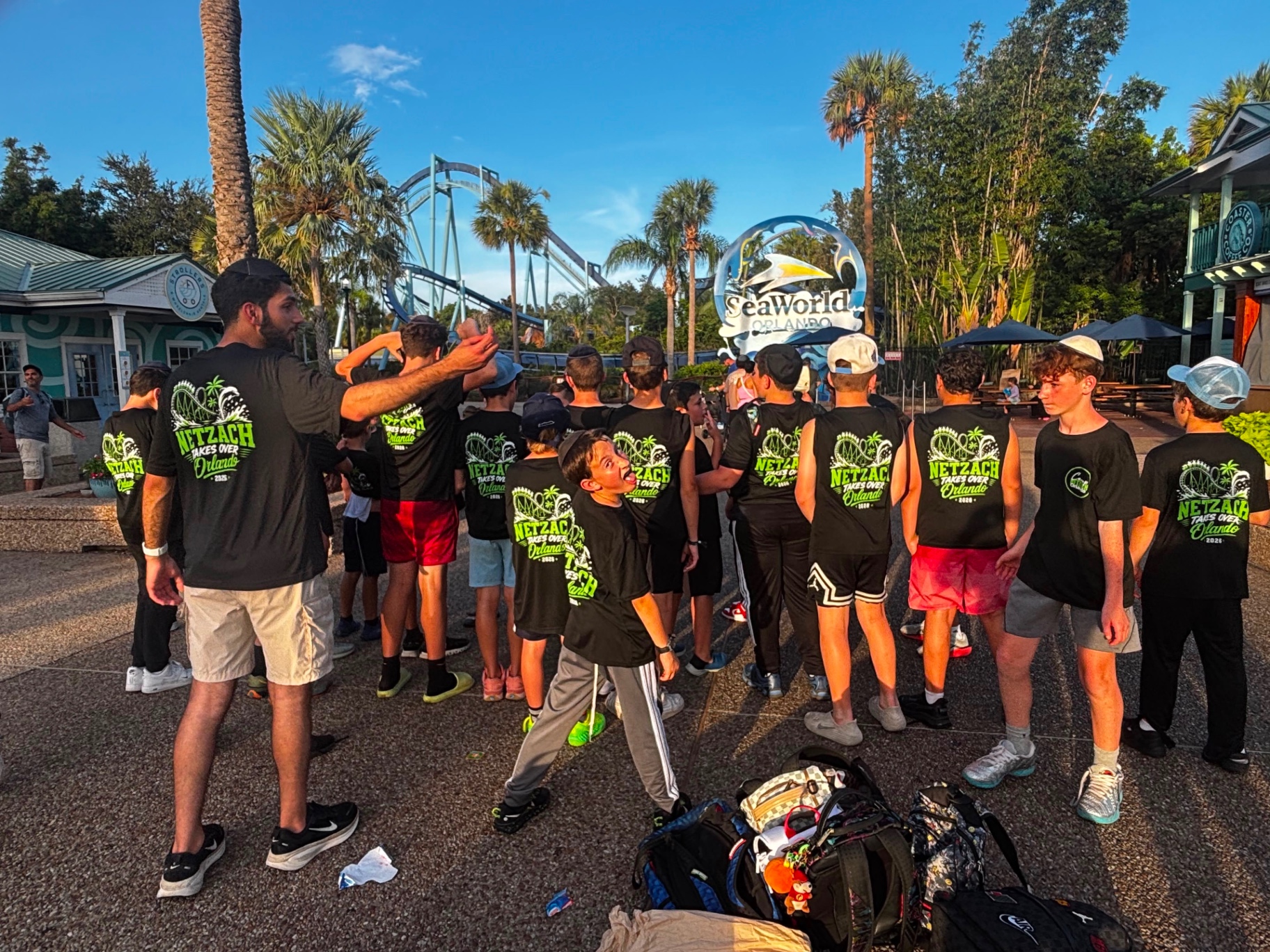 A camp group in matching shirts gathered in a plaza near the SeaWorld Orlando sign
