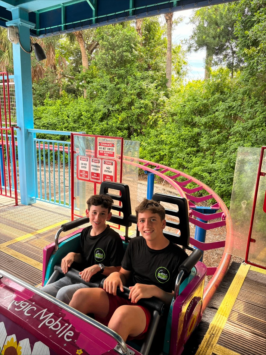 Two campers in matching shirts riding a roller coaster