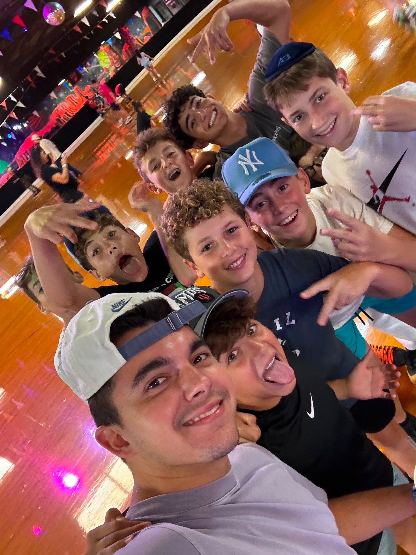 A group of campers and a counselor posing in a selfie at the skating rink