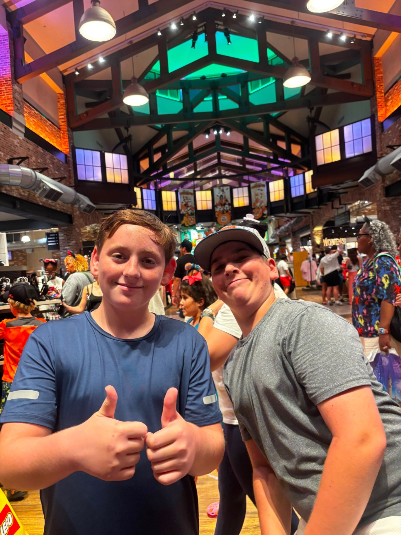Two campers giving thumbs-up while shopping in a crowded store
